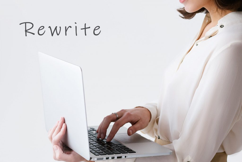 ノートPCで「Rewrite」と書かれた文字を打ち込む女性