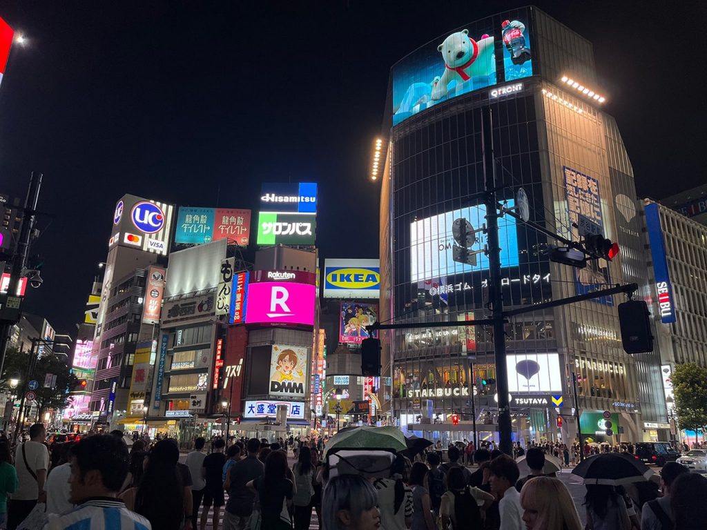 渋谷スクランブル交差点の夜景、多数のブランドロゴが光る